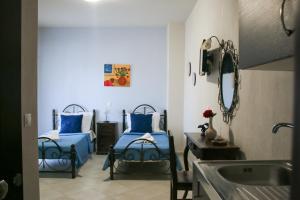 a bathroom with two beds and a sink and a mirror at Studios Liotrivi Ouranoupolis in Ouranoupoli