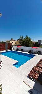 a swimming pool with chairs next to a building at new bv carlos paz in Villa Carlos Paz