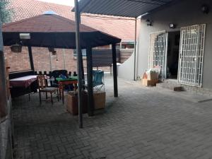 a patio with an umbrella and a table and chairs at Lamenatseach 300 in Leeupoort +1 photo