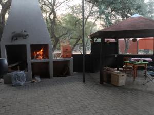 a fireplace in a patio with a fire place at Lamenatseach 300 in Leeupoort