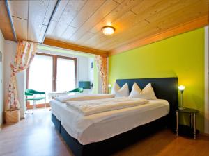 a bedroom with a large bed with a green wall at Landpension Am Sommerhang in Bad Rippoldsau