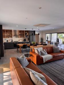 a living room with two brown couches and a kitchen at First Light Serenity in Hluhluwe
