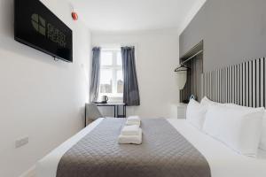 a bedroom with a bed with two towels on it at Southern Cross in Watford +38 photos