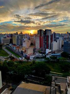 a view of a city with the sun setting at Ryokan in São Paulo