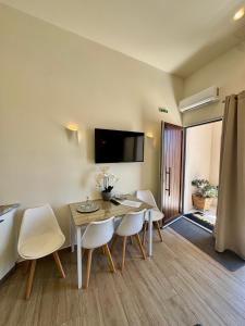 a dining room with a table and white chairs at Ano Syros Orient in Ano Syros