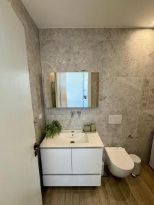 a bathroom with a sink and a toilet and a mirror at Ano Syros Orient in Ano Syros +27 photos