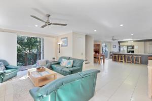 a living room with blue couches and a kitchen at Flip Flop Inn in Amity Point