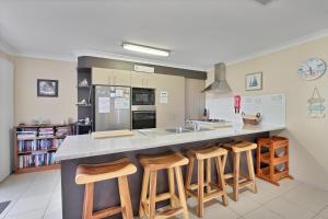 a kitchen with a counter with bar stools at Flip Flop Inn in Amity Point +7 photos