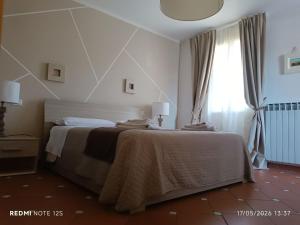 a bedroom with a bed and a window at La casetta del poggio in Poggio a Caiano