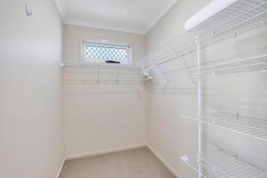 a walk in closet with white shelves and a window at Flip Flop Inn in Amity Point