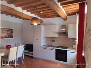 a kitchen with white cabinets and a table with chairs at La casetta del poggio in Poggio a Caiano