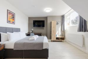 a bedroom with a large bed with white pillows at Southern Cross in Watford