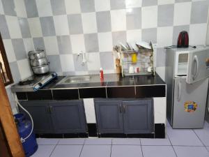 a small kitchen with a sink and a refrigerator at Residence samy in San-Pédro +7 photos