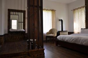 a bedroom with a bed and a mirror and a chair at VELORA-DOODHPATHRi in Aphit