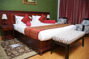 a bedroom with a large bed with red pillows at Eagle Palace Hotel in Nakuru +22 photos