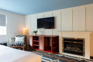 a bedroom with a fireplace and a tv and a bed at Driftaway Hotel and Pool in Ogunquit