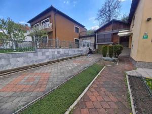 a person walking down a sidewalk in front of a building at Apartman Bistrivoda 2 in Vogošća +5 photos