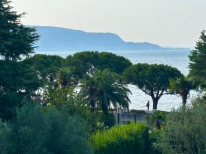 a person standing on a beach next to the water at Casa Cristina Giulia in Toscolano Maderno