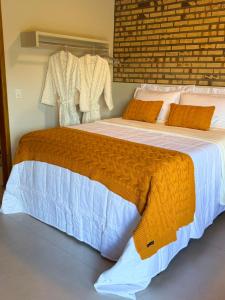 a bedroom with a large bed with an orange blanket at Chalé Saúde in Venda Nova do Imigrante