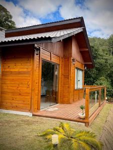 a small wooden cabin with a large glass door at Chalé Saúde in Venda Nova do Imigrante