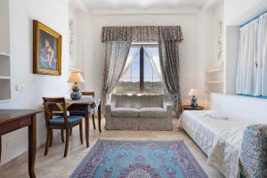 a bedroom with a bed and a chair and a desk at B&B Villa Clodia in Saturnia +35 photos