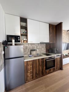 a kitchen with wooden cabinets and a stainless steel refrigerator at Crown TiM Villa in Vrnjačka Banja