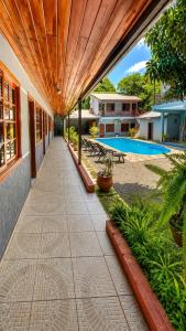 a walkway next to a building with a wooden ceiling at Hostel Peter Pan in Puerto Iguazú