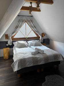 a bedroom with a bed with a large window at Nase Chaty- domki z balią, termy i natura in Biały Dunajec