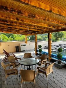 a patio with tables and chairs and a pool at Vikendica Vesic Tegare in Bratunac