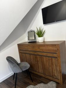 a desk with a chair and a television on a wall at Nase Chaty- domki z balią, termy i natura in Biały Dunajec