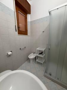 a bathroom with a toilet and a glass shower at La casa di GiòGiò in San Vito lo Capo +27 photos