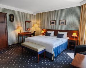 a hotel room with a large bed and a chair at Wellness Golf Hotel Morris in Mariánské Lázně +58 photos