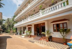 a large white house with a balcony at Luxury Apartment With Farm View in Siolim