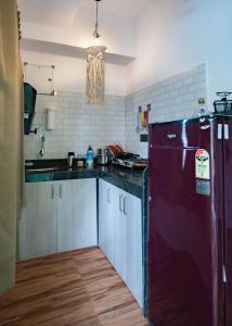a kitchen with a purple refrigerator in a room at Luxury Apartment With Farm View in Siolim