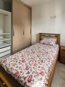 a bedroom with a bed with a floral bedspread at Bela Vista Por do Sol in Espirito Santo Do Pinhal