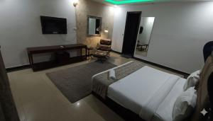 a hotel room with a bed and a desk and a chair at Hotel Marina Premium Near IGI Airport Delhi in New Delhi +20 photos
