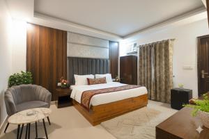 a hotel room with a bed and a chair at Hotel Marina Premium Near IGI Airport Delhi in New Delhi