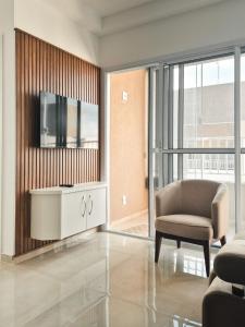 a living room with a chair and a television at Bela Vista Por do Sol in Espirito Santo Do Pinhal