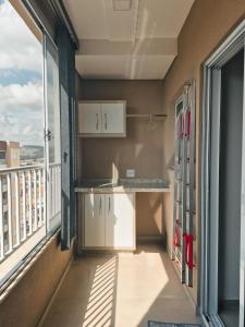 an empty room with a kitchen and a balcony at Bela Vista Por do Sol in Espirito Santo Do Pinhal