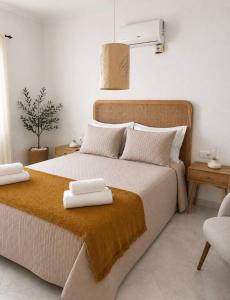 a bedroom with a large bed with two towels on it at Villa Vistamar - Piscina privada, vistas al mar y a 5 min de la playa in Cala en Porter +11 photos