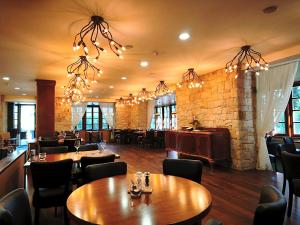 a restaurant with tables and chairs and a brick wall at Wellness Golf Hotel Morris in Mariánské Lázně