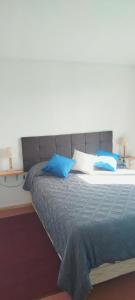 a bed with blue pillows on it in a room at Cabaña lomas de chaica in Puerto Montt +27 photos