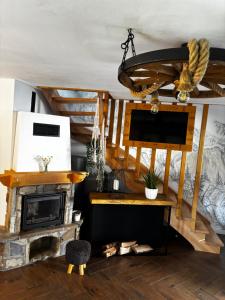 a living room with a fireplace and a chandelier at Nase Chaty- domki z balią, termy i natura in Biały Dunajec