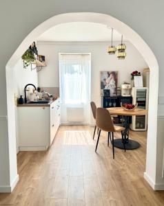 an archway in a kitchen with a table and chairs at La Folie Blanche in Vertou