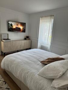 a bedroom with a bed and a tv on the wall at La Folie Blanche in Vertou