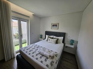 a bedroom with a large bed and a large window at DiROMANE in Braga