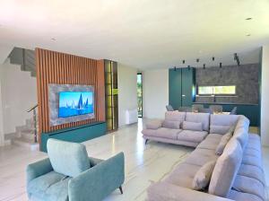 a living room with two couches and a tv at Azure Garden Villa 317 in Lalzit Bay