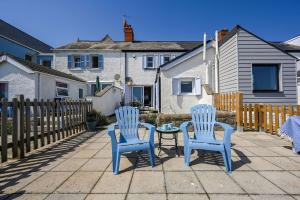two blue chairs and a table on a patio at Driftwood Cottage by Bloom Stays in Folkestone