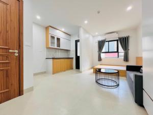 a kitchen and a living room with a table at Ahmed Rifan Hotel in Kulhudhuffushi
