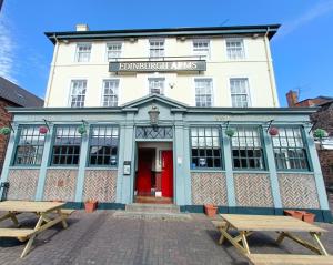 a building with two picnic tables in front of it at Edinburgh Arms in York